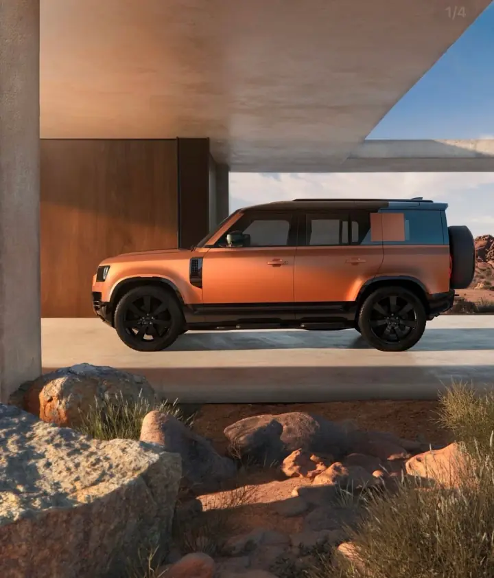 Land Rover Defender framed by modern desert architecture