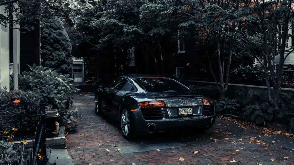 A sleek Audi R8 parked in a leafy residential driveway in Cape May, NJ, showcasing elegance and luxury.