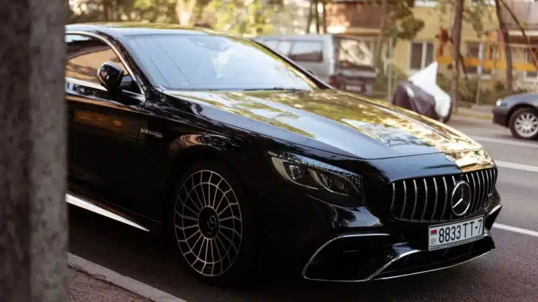 Luxury black car parked on an urban street, displaying elegance and sophistication.