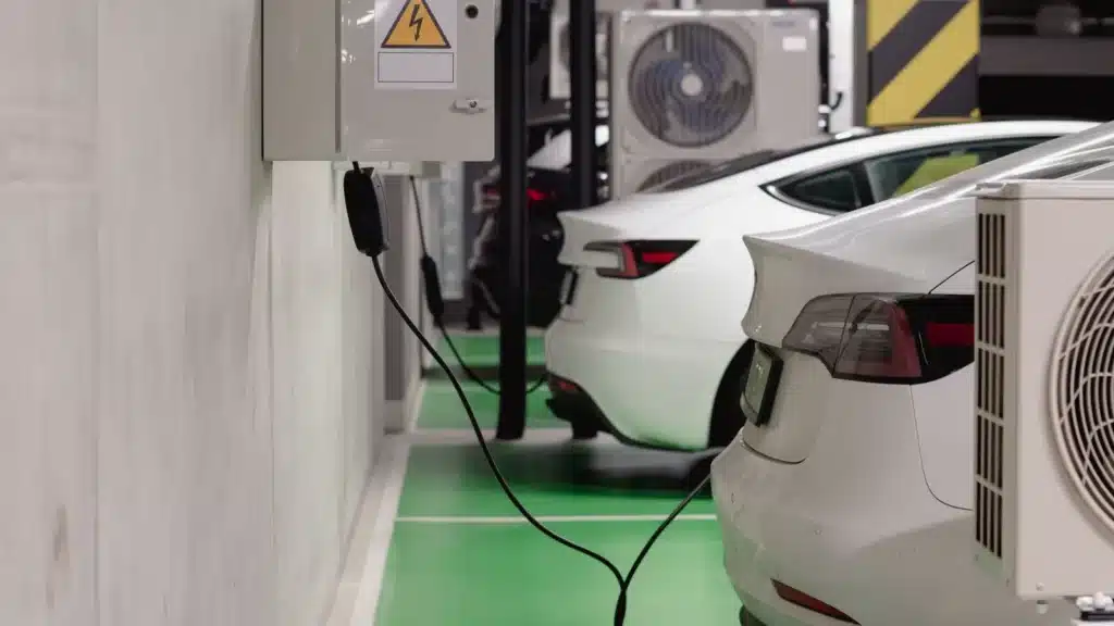 Electric vehicles charging at an indoor station in a modern underground garage.