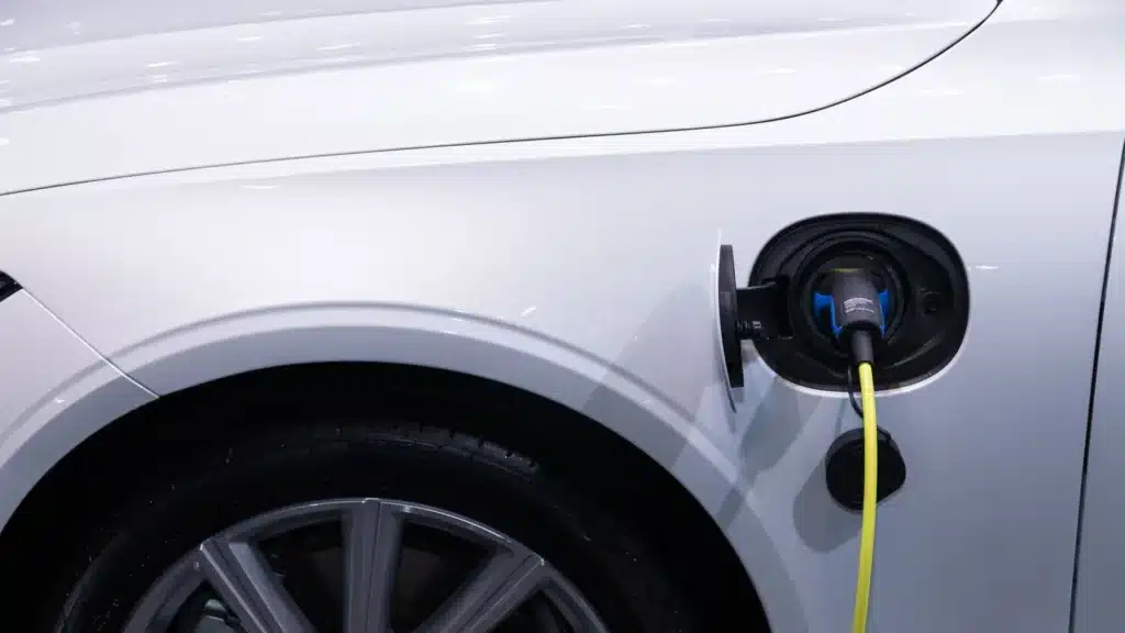 A white electric car plugged in for charging.