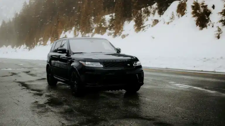 A sleek black SUV driving on a mountain road.